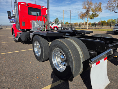 Kenworth T880 2020 Conventional Daycab chassis with dual rear axles and chrome wheels, red cab, fuel tanks, fifth wheel area visible.