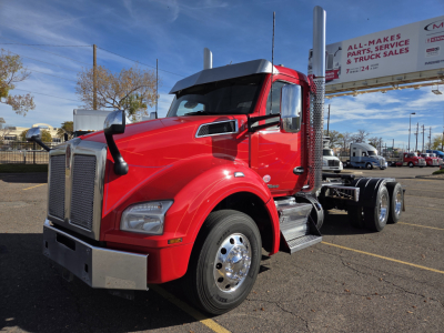 Kenworth T880 conventional daycab truck in red, front-left view with chrome exhaust stacks and dual rear axles.