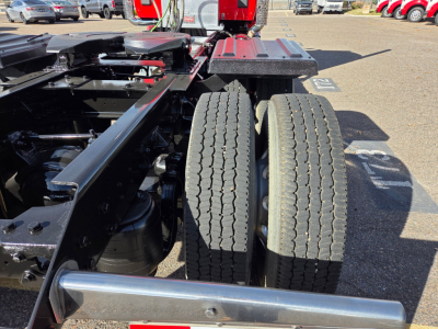 Kenworth T880 chassis with dual rear wheels and metal frame visible; close-up of wheel area and frame components.
