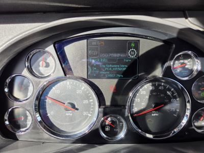 Kenworth T880 instrument cluster and digital display showing vehicle metrics and engine software info.
