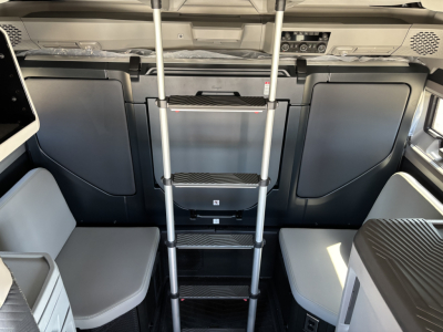 Volvo VNL64T860 sleeper cab interior with ladder/steps and seating visible, cabin control area at front, grey and black trim.