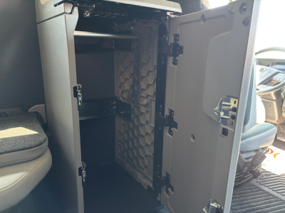 Volvo VNL64T860 truck cab interior with open bunk storage cabinet showing shelves and foam padding behind door