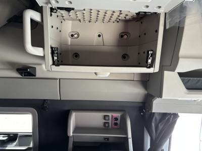Volvo VNL64T860 interior dashboard area showing center console and open overhead storage compartment.