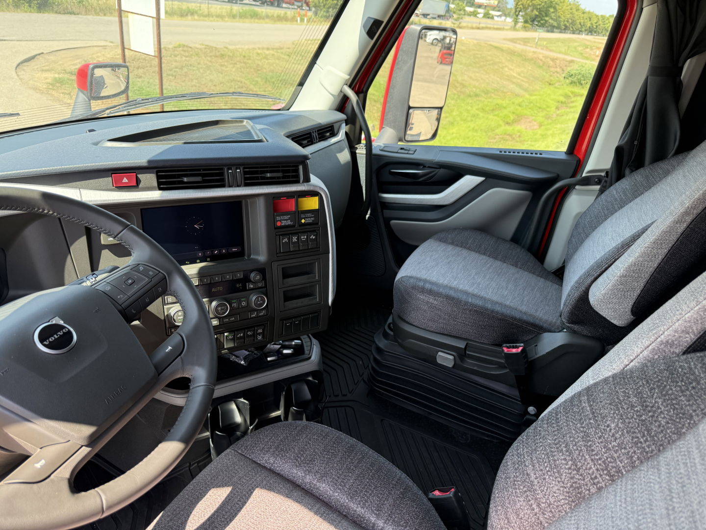 Volvo VNL64T840 truck interior showing steering wheel, dashboard, and driver seat with center console area.