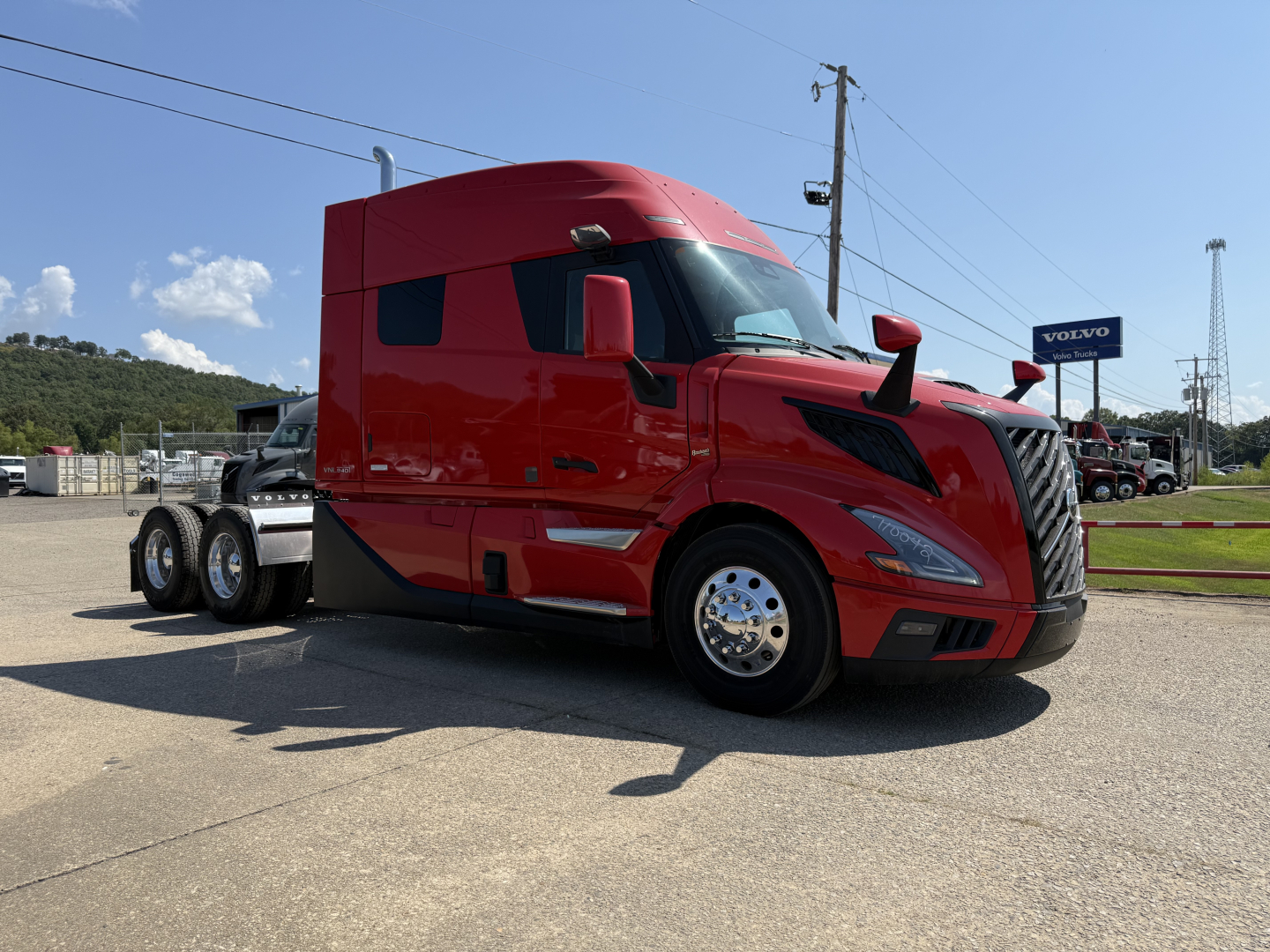 Volvo VNL64T840 sleeper cab truck in red, side view with front grille and chrome wheels.