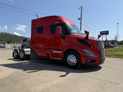 2026 Volvo VNL64T840 tractor truck in red, side view, with sleeper cab and chrome wheels; truck parked outdoors.
