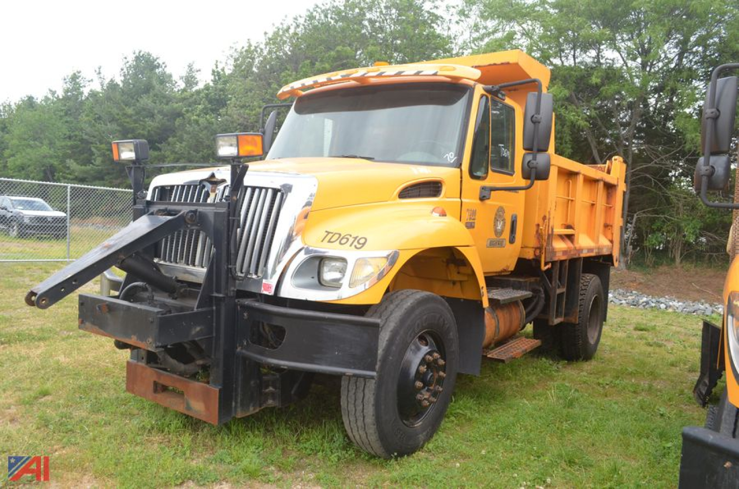 International Workstar 7300 dump truck in yellow with front grille guard and dual rearview mirrors