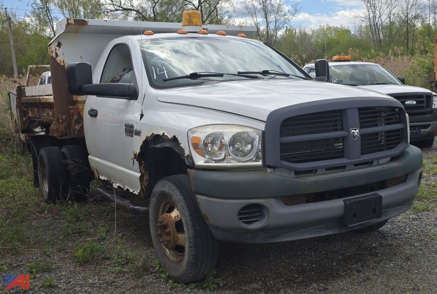 2008 Dodge Ram 3500 heavy duty dump truck in-service with rusted dump bed and front bumper; white cab, dual rear wheels, orange clearance lights, and side step.