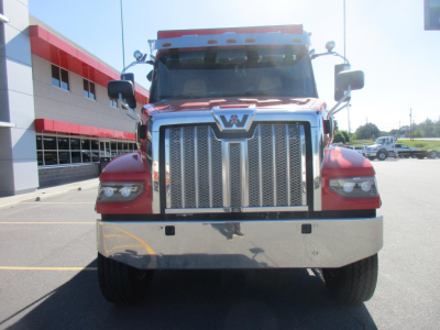 Front view of a red Western Star 47X dump truck with chrome grille, large bumper, and side mirrors visible.