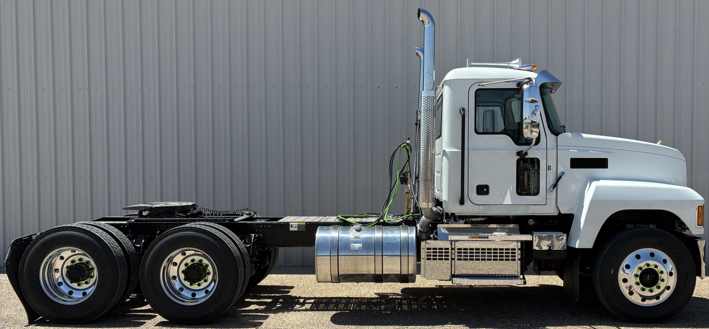 Truck chassis side view showing 10-wheel configuration with cab and fuel tanks.