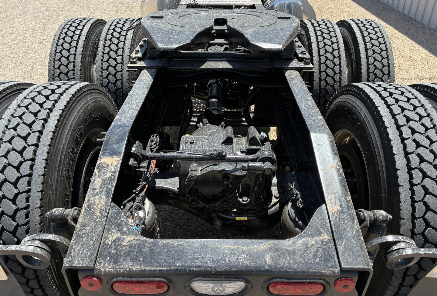 Mack PI64T chassis undercarriage showing rear dual axle suspension and drivetrain components with label text not visible.