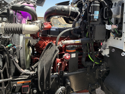 Mack PI64T engine bay with red engine, hoses, and black components visible; labels and wiring harnesses present.