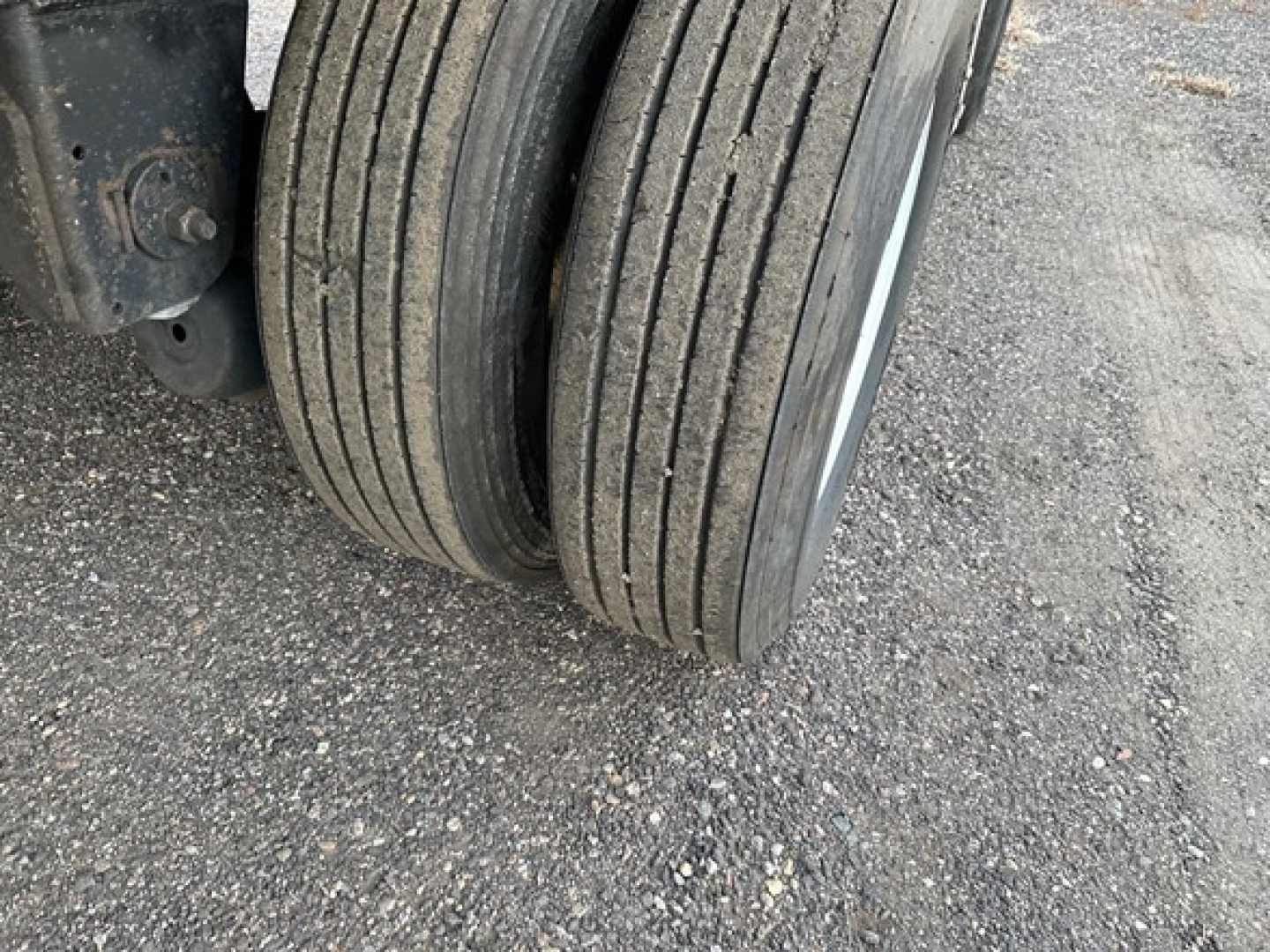 Trailer axle and dual tires from a 2013 utility spread air combo flatbed showing worn tread and...