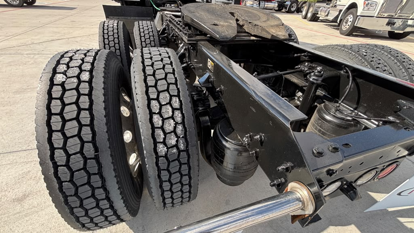 Kenworth T680 chassis and dual rear tires showing wheel hubs and frame with hydraulic components visible.