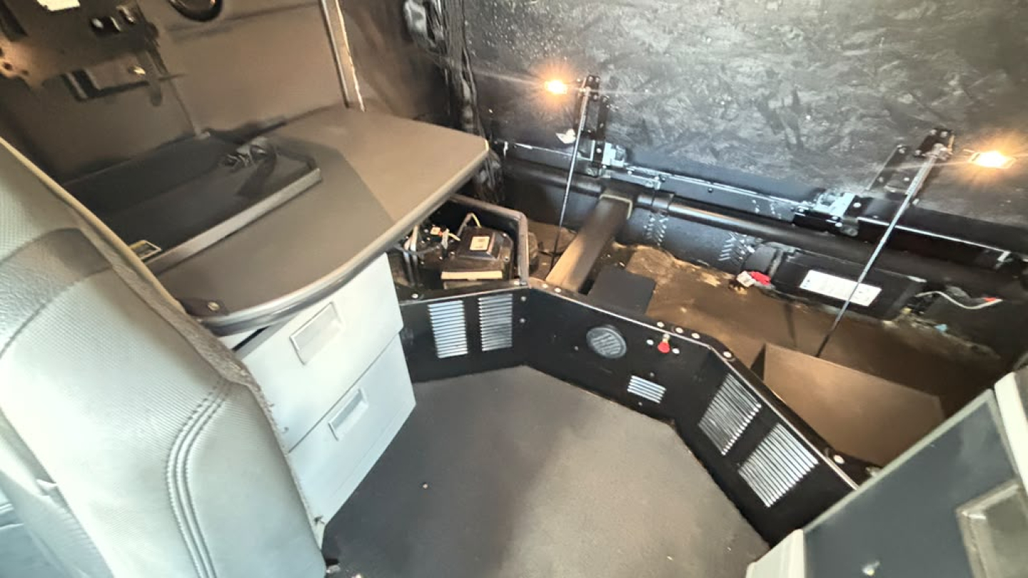 Kenworth T680 interior cab view showing dashboard area and center console with storage drawers and control panels.