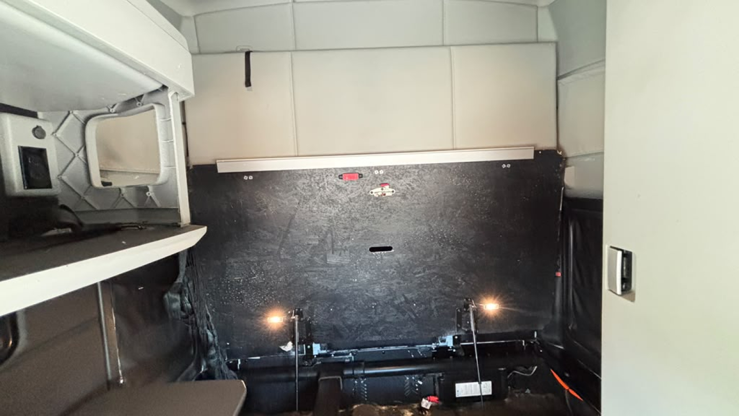 Kenworth T680 sleeper cab interior cargo area with storage partition, LED lights, and side panels visible.