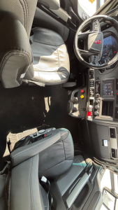 Kenworth T680 cab interior showing steering wheel dashboard controls seats and center console