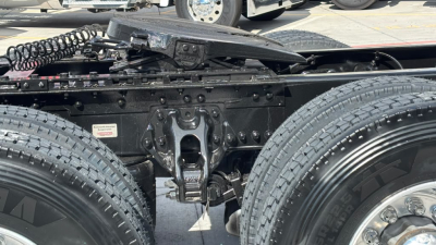 Kenworth T680 chassis with dual rear axles and visible suspension components in a used truck, showing frame, wheels, and electrical harnesses.