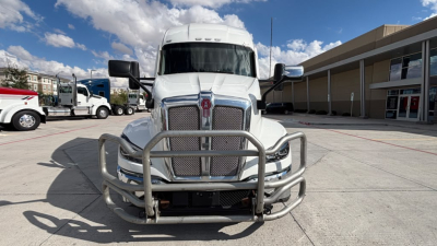 Kenworth T680 front view with grille guard and large chrome bumper showing front of truck with white cab and badges