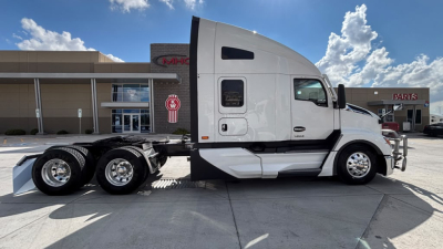 Kenworth T680 tractor cab side view showing sleeper area and tandem rear wheels with dual axle configuration.