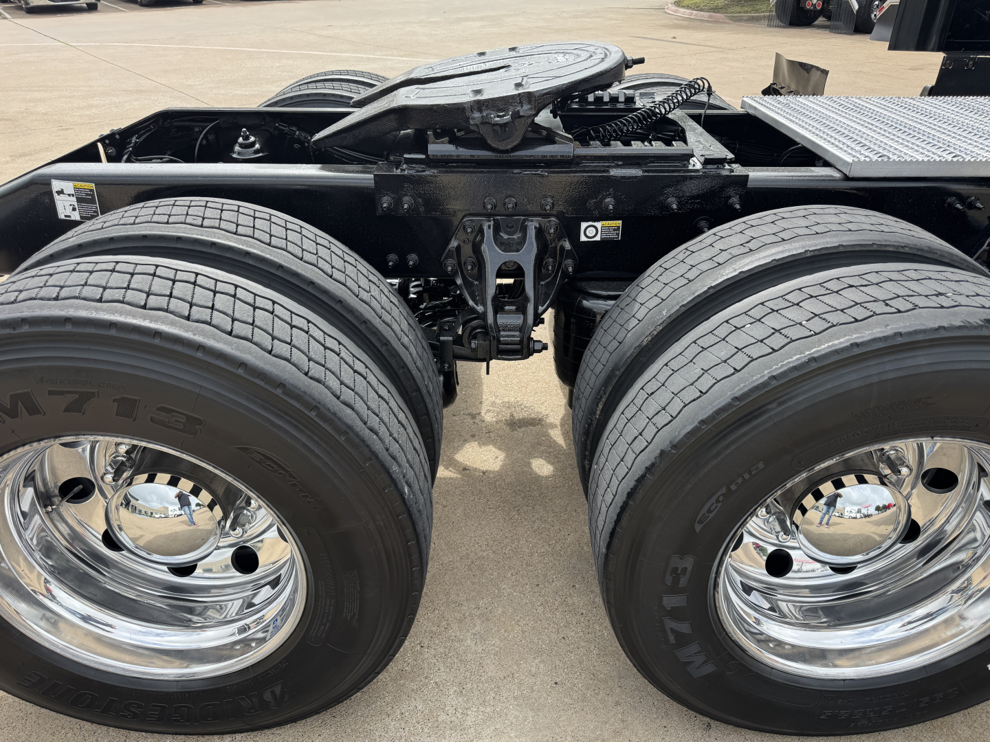 Peterbilt 579 chassis view showing dual rear axles and tires, chrome wheels, and fifth wheel area.