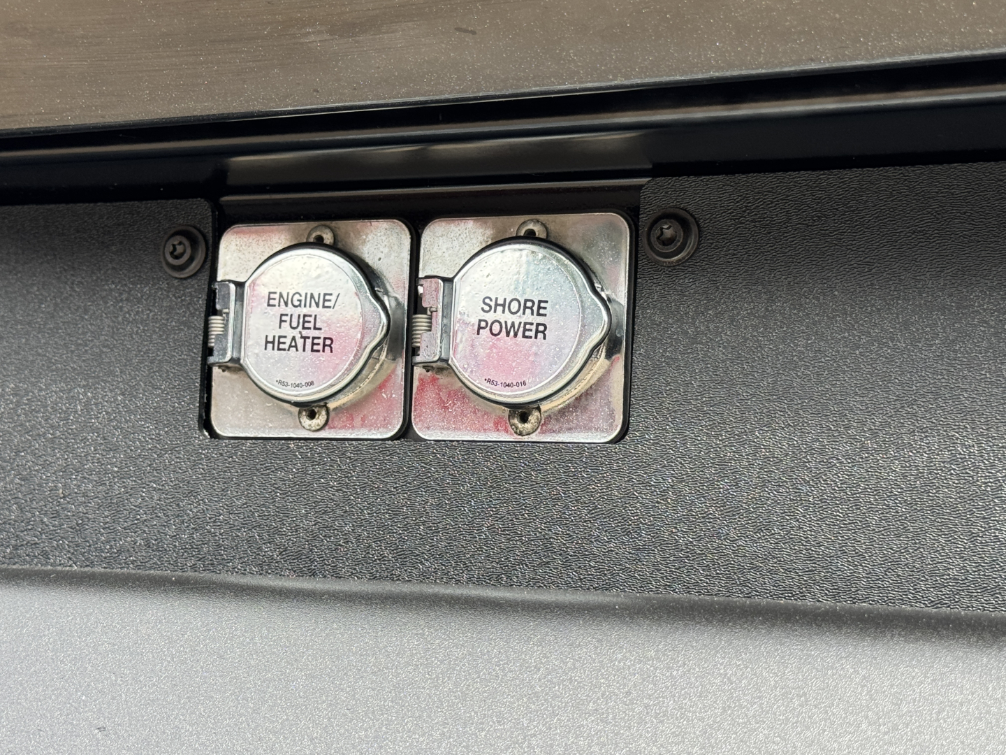 Peterbilt 579 engine bay switches showing Engine/Fuel Heater and Shore Power caps.
