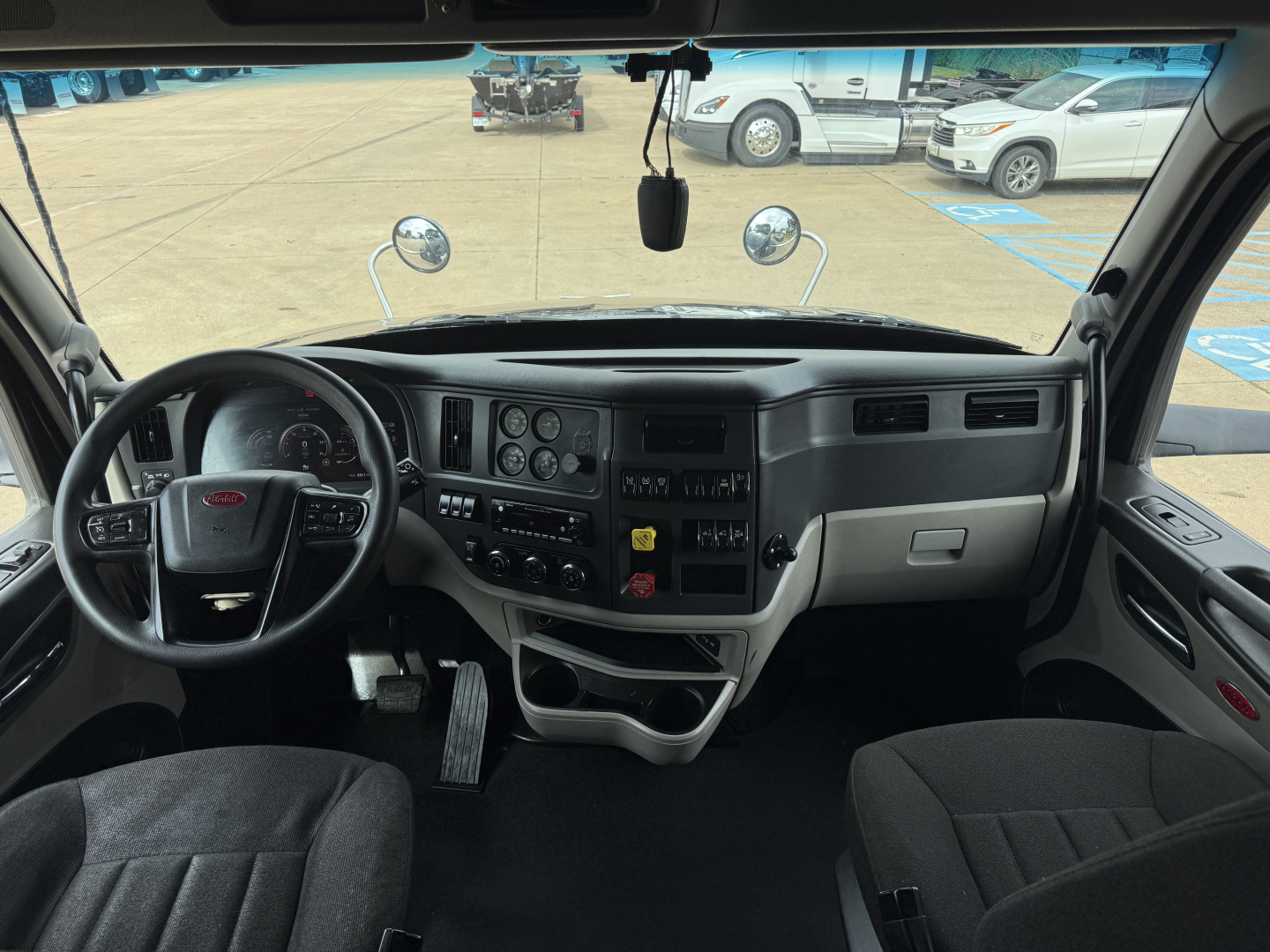 Peterbilt 579 truck interior showing steering wheel, dashboard, and driver seat with instrument cluster and center console.