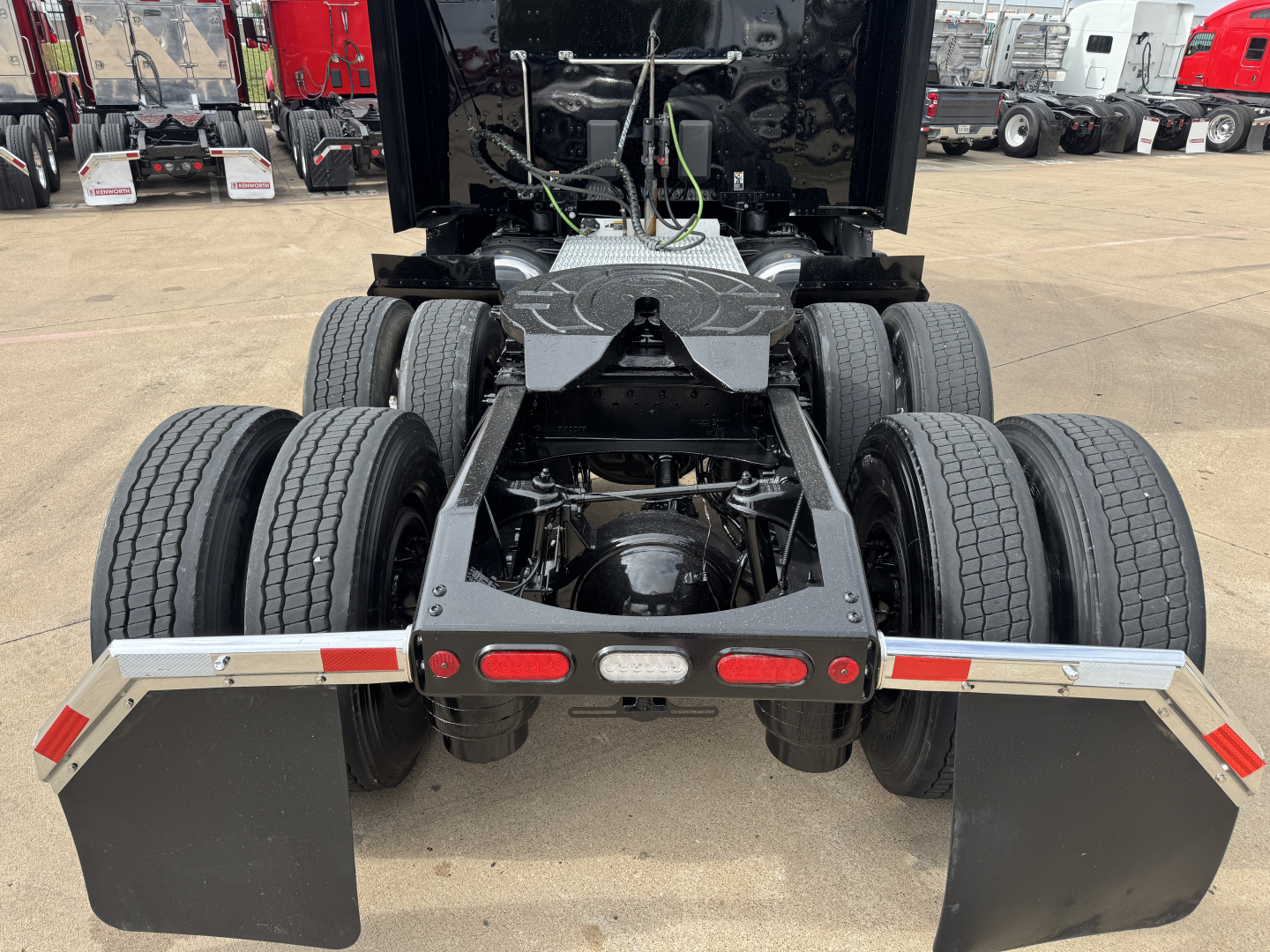 Peterbilt 579 chassis rear view showing dual rear axles, fifth wheel mount, mud flaps, and rear bumper with lights.