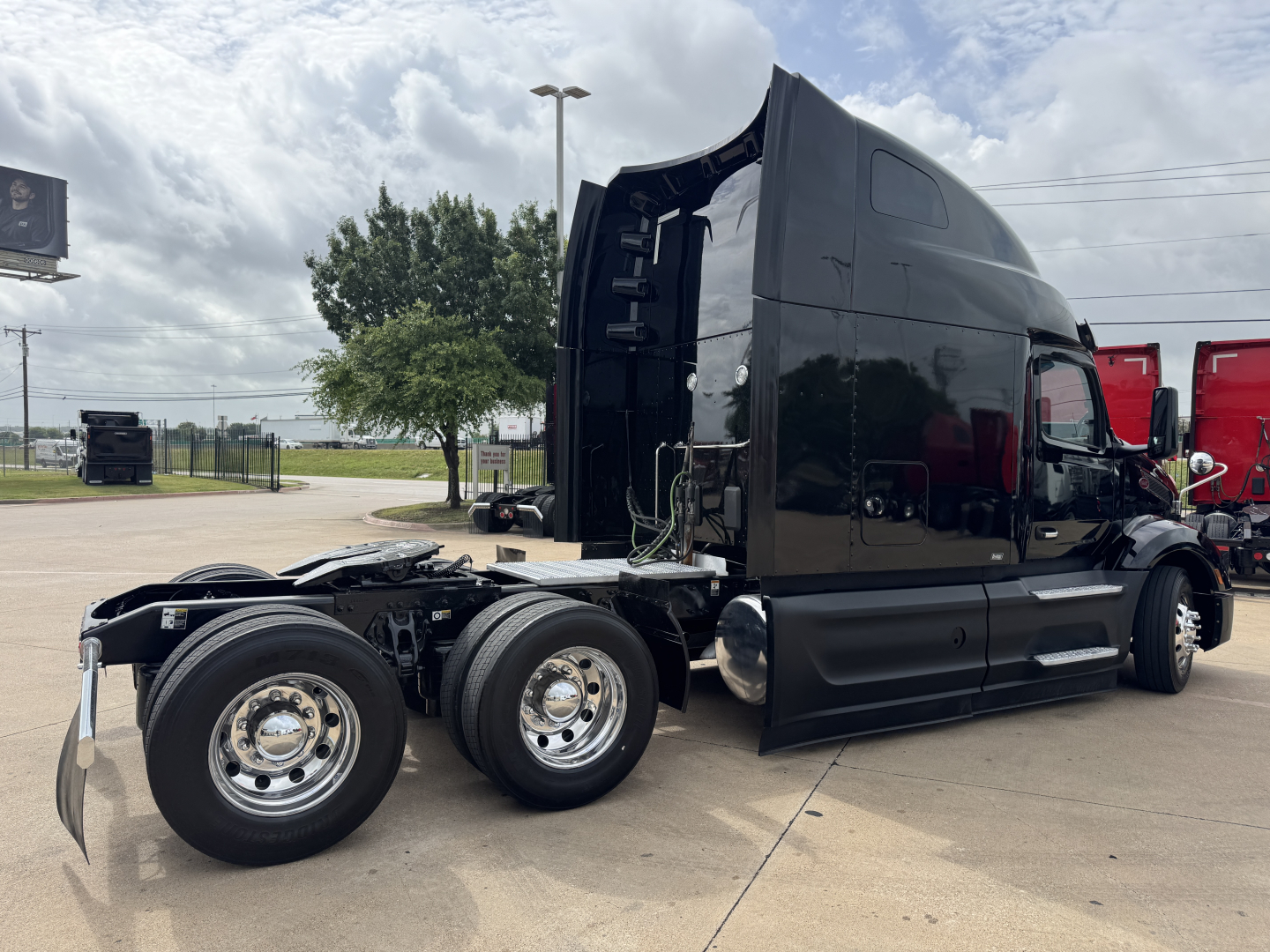 Peterbilt 579 truck cab and chassis in a parking lot, black exterior, No. visible text on cab, dual rear axles, chrome wheels.
