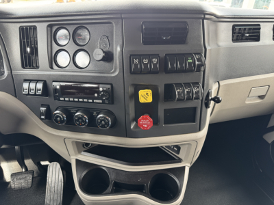 Peterbilt 579 dash and center console showing gauges, switches, and cup holders in a used truck interior.