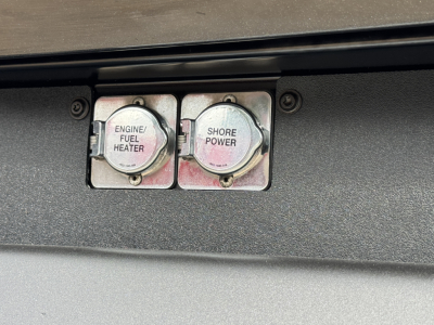 Peterbilt 579 engine bay switches showing Engine/Fuel Heater and Shore Power caps.