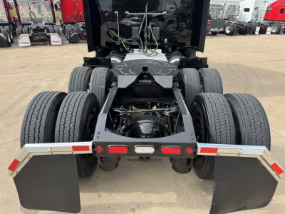 Peterbilt 579 chassis rear view showing dual rear axles, fifth wheel mount, mud flaps, and rear bumper with lights.