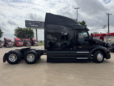 Peterbilt 579 tractor unit in black paint seen from side; two rear axles chassis visible; fuel tanks and chrome wheels; no visible damage.