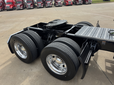 Peterbilt 579 tractor cab chassis rear view showing dual rear axles and chrome wheels. VIN plate not visible.