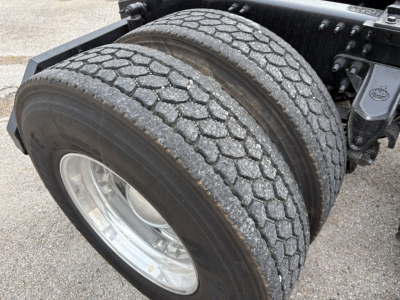 Dual rear truck tires on a Mack PI64T tractor, with tread, wheel rims, and part of the chassis visible
