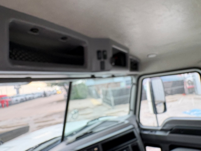 Truck cabin interior showing overhead console and dashboard view from left side with windows and control panels.