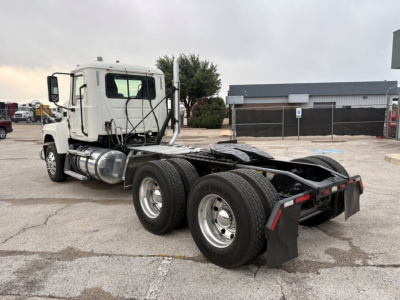 Mack PI64T conventional daycab tractor showing side view with dual rear axles and fuel tanks.