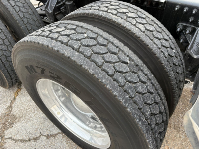Mack PI64T truck dual rear tires showing large tread with M2 series marking on the tire sidewall.