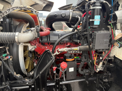 Mack PI64T truck engine bay with visible MPI turbo, hoses, wiring harnesses, and red engine components.