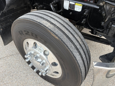 Mack PI64T truck front wheel view showing dual rear-axle? front dual tires R28 label on tire tread with wheel hub and brake components visible.