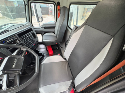Cab interior of a 2020 Mack PI64T conventional daycab showing steering wheel, dashboard with numerous gauges, two-tone cloth seats, and center console.