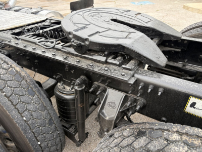 Tractor cab chassis area of a 2020 Mack PI64T showing drivetrain U-bolt area, hydraulic lines, frame Rails, and fifth wheel base with components.