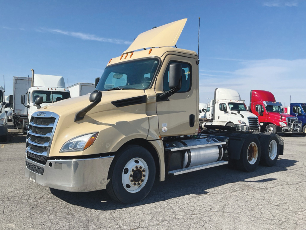 Freightliner Cascadia126 daycab truck in beige with open hood showing front grille and side fuel tanks.