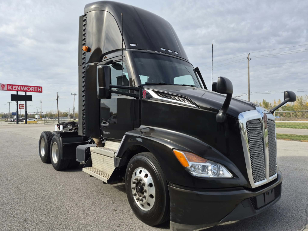 Kenworth T680 conventional daycab truck side view showing bold chrome grille and black cab