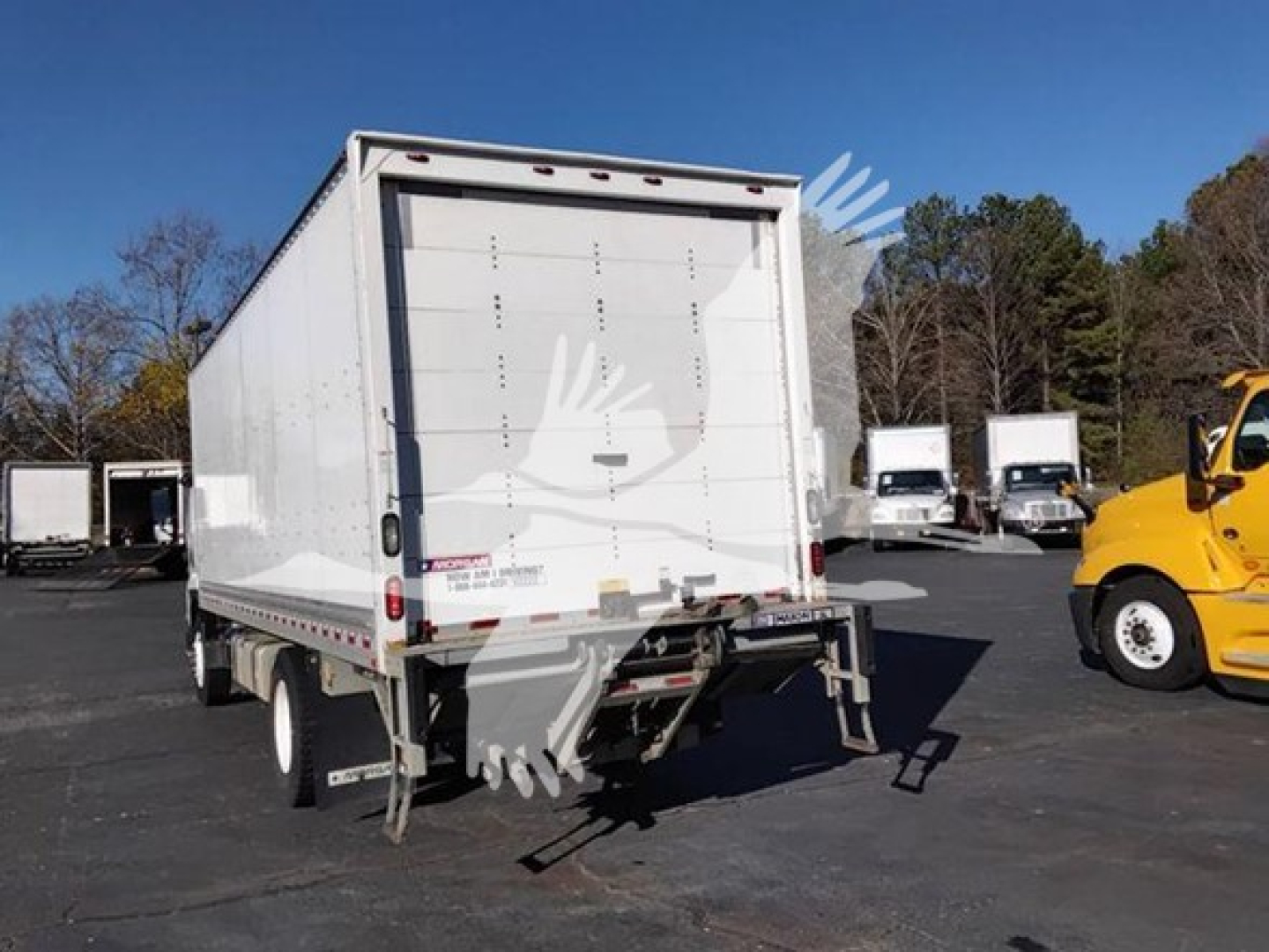 Isuzu FTR box truck rear view showing cargo area with closed roll-up doors and rear underride guard.