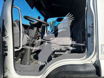 Isuzu FTR cab interior and steering wheel view from open driver door showing dashboard and seat.