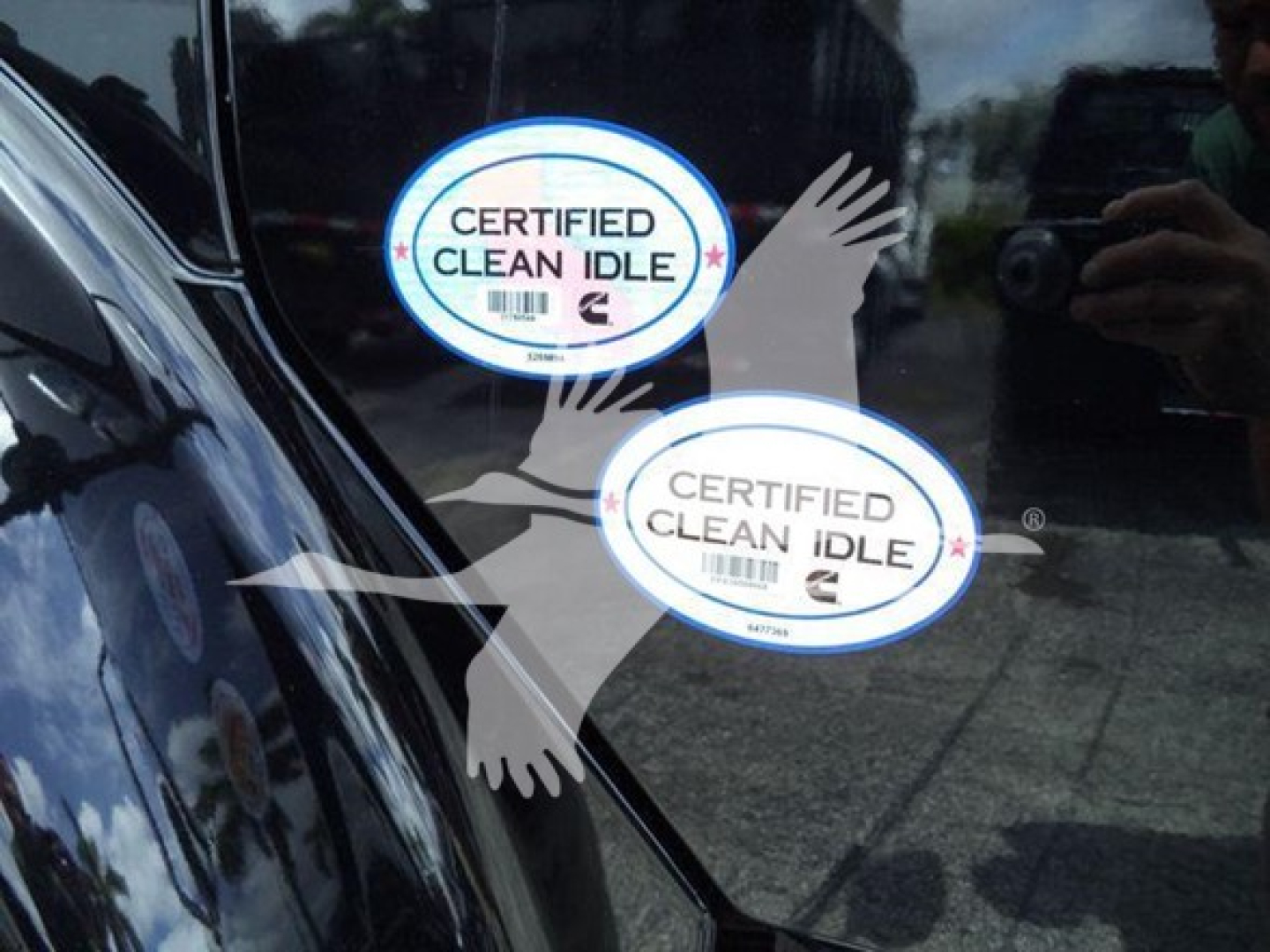 Rear window of a Freightliner M2 106 showing two Certified Clean Idle stickers.