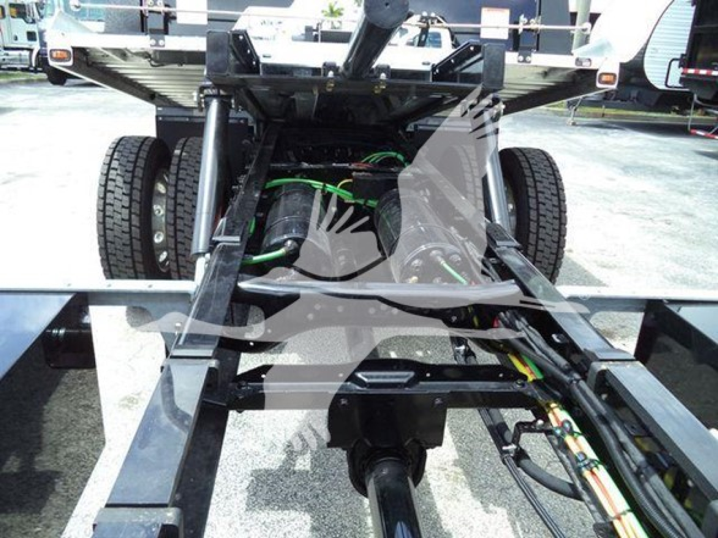 Freightliner M2 106 chassis view showing suspension, drive shaft, and frame rails with wiring harnesses.