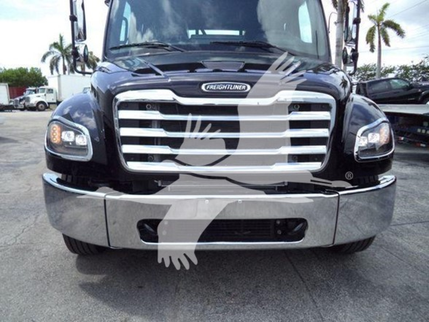 Freightliner M2 106 truck front view showing chrome grille, headlights, and bumper with Freightliner emblem.