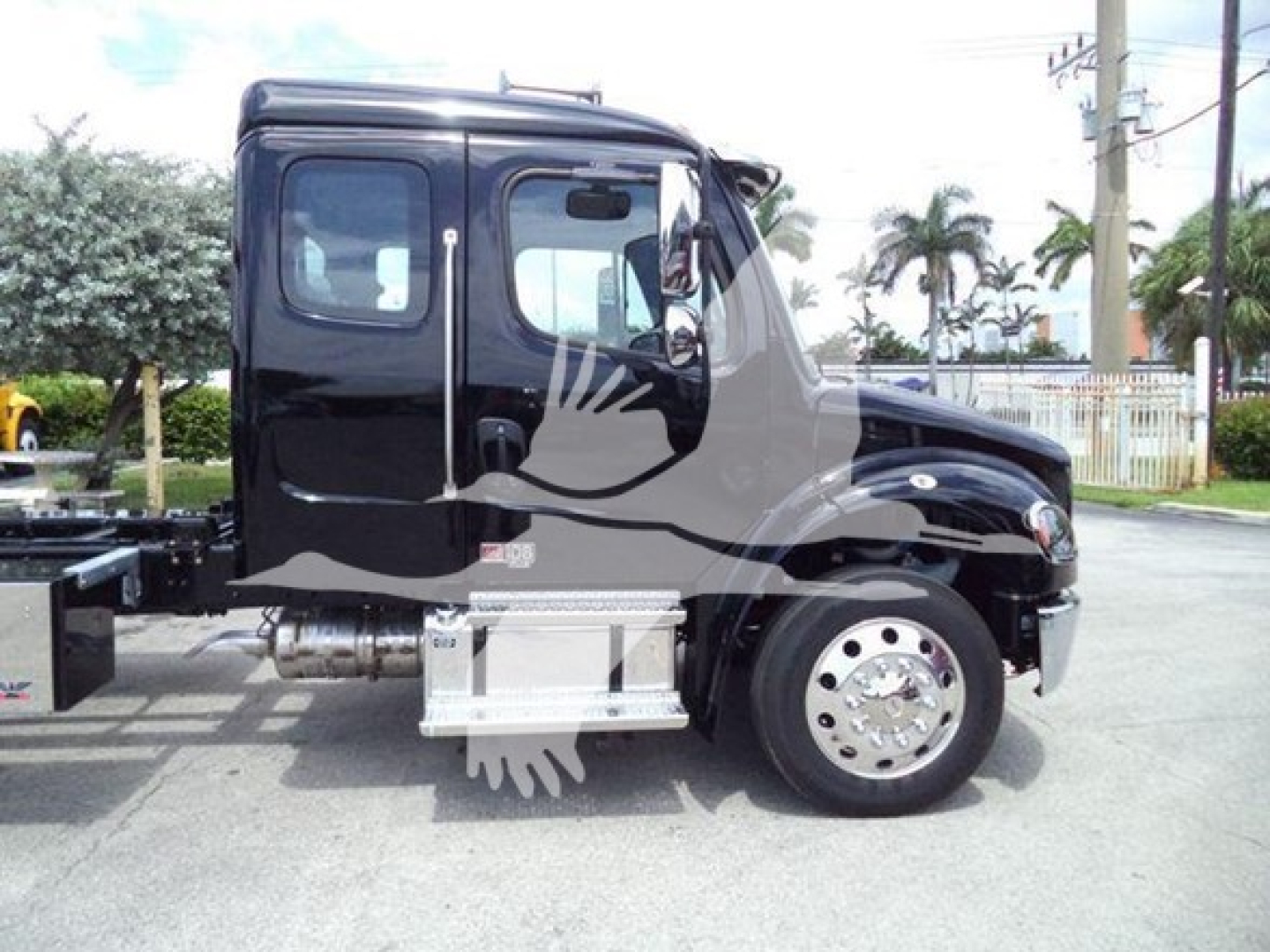 Truck cab profile of a 2027 Freightliner M2 106 rollback showing black exterior, side steps, and front wheel/view.